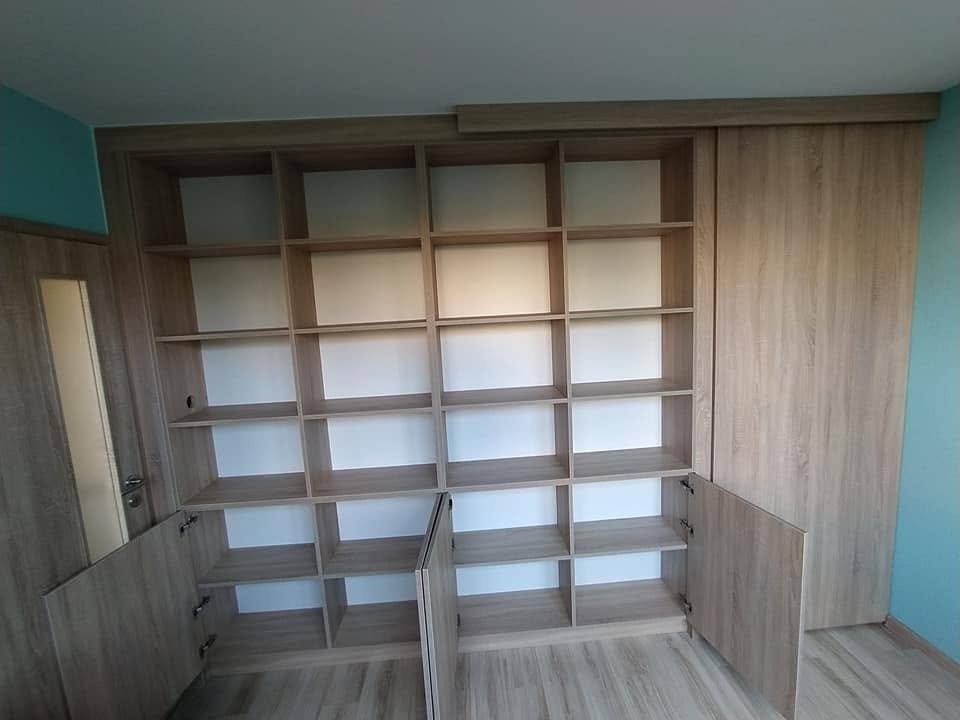 Eichen-Bücherwand über die ganze Wand mit unteren Schiebepaneelen