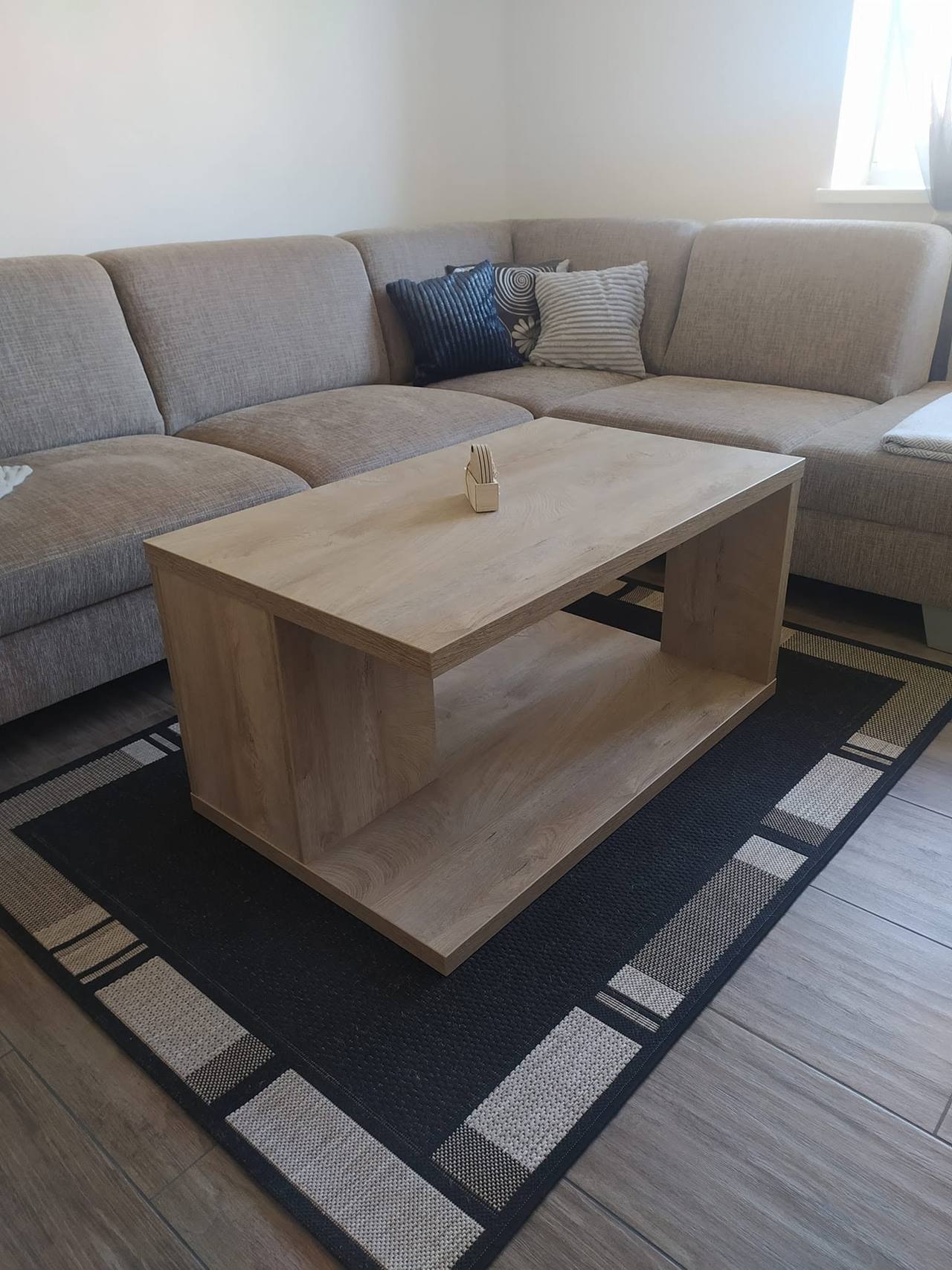 Couchtisch in grauer Eichenoptik vor dem beigen Sofa