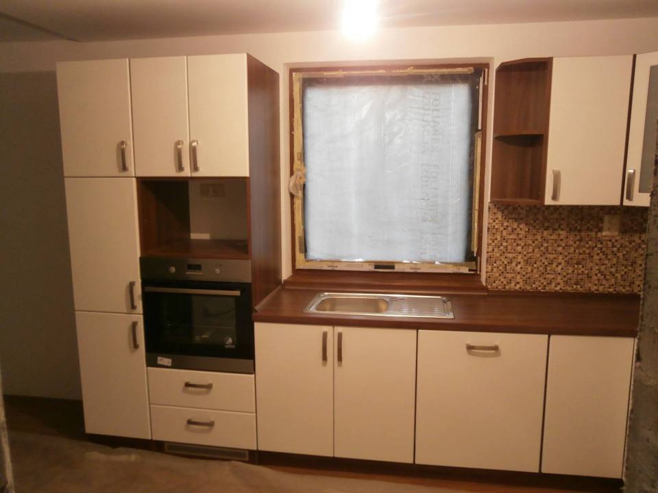 Cremefarbene Küche ums Fenster mit Mosaikfliesen und Backrohr