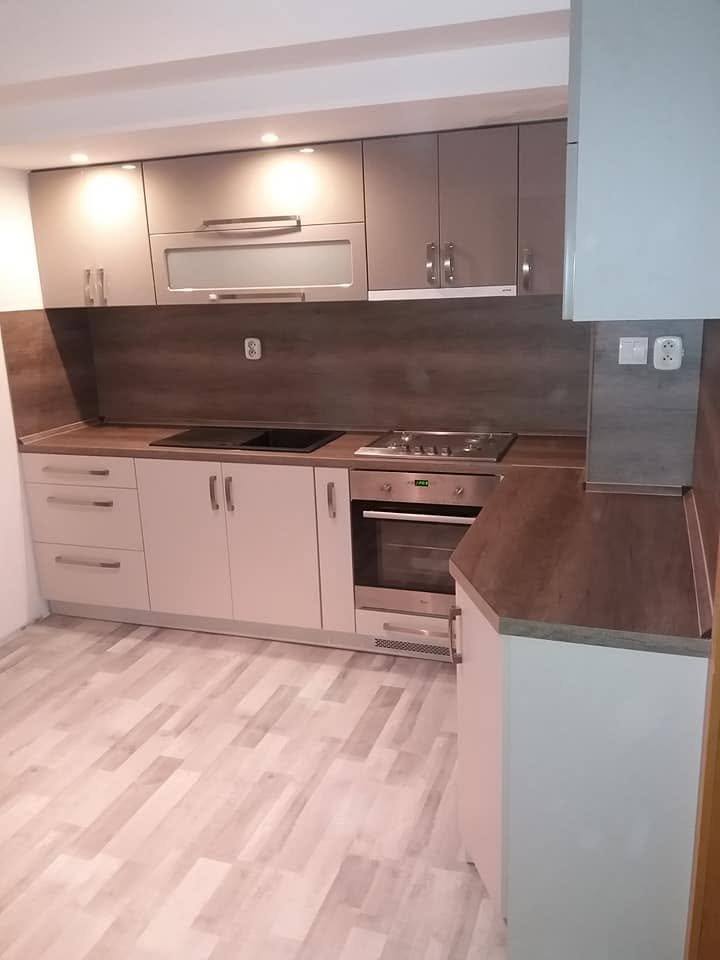 Blick auf die cremefarbene Küchenzeile mit hellem Holzboden.