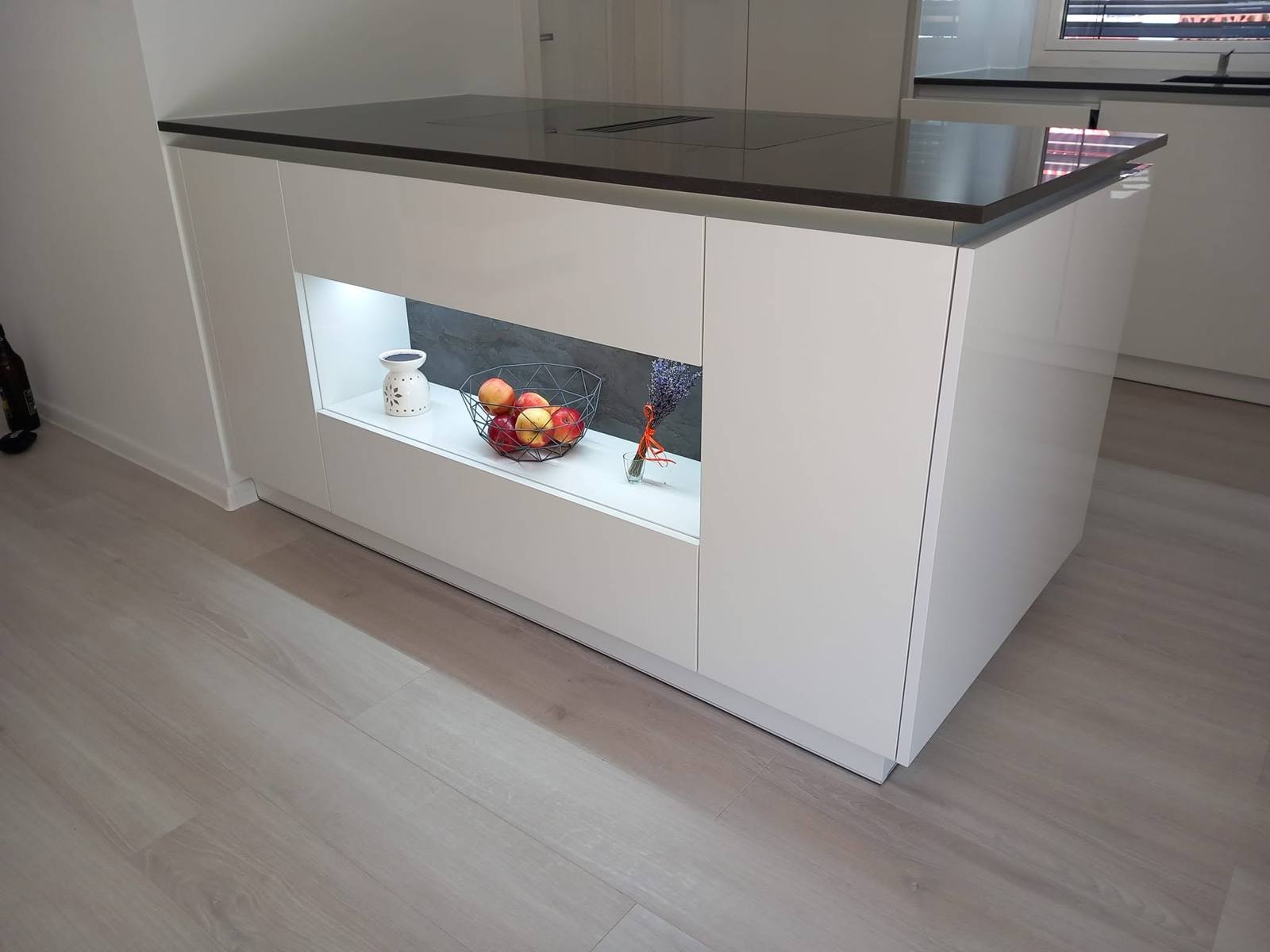 Kücheninsel mit dunkler Platte und LED-beleuchteter Nische
