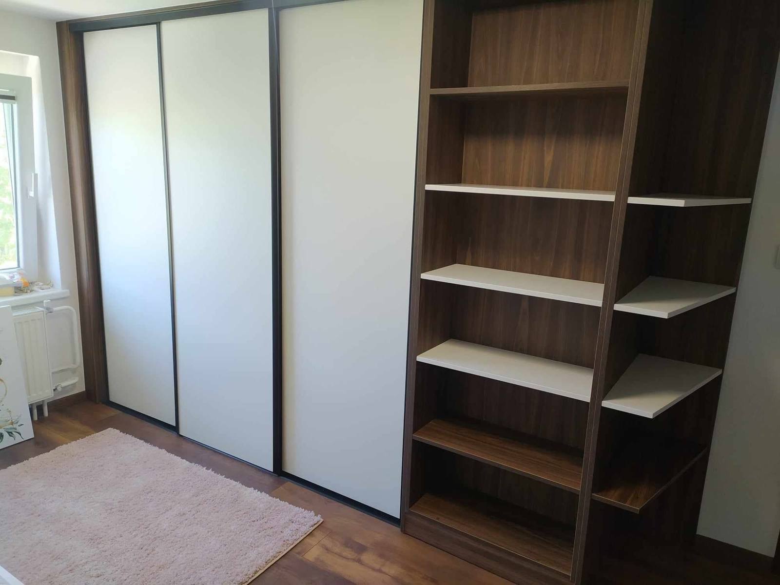 Zatvorené krémové posuvné dvere vedľa regálu v dekore orecha