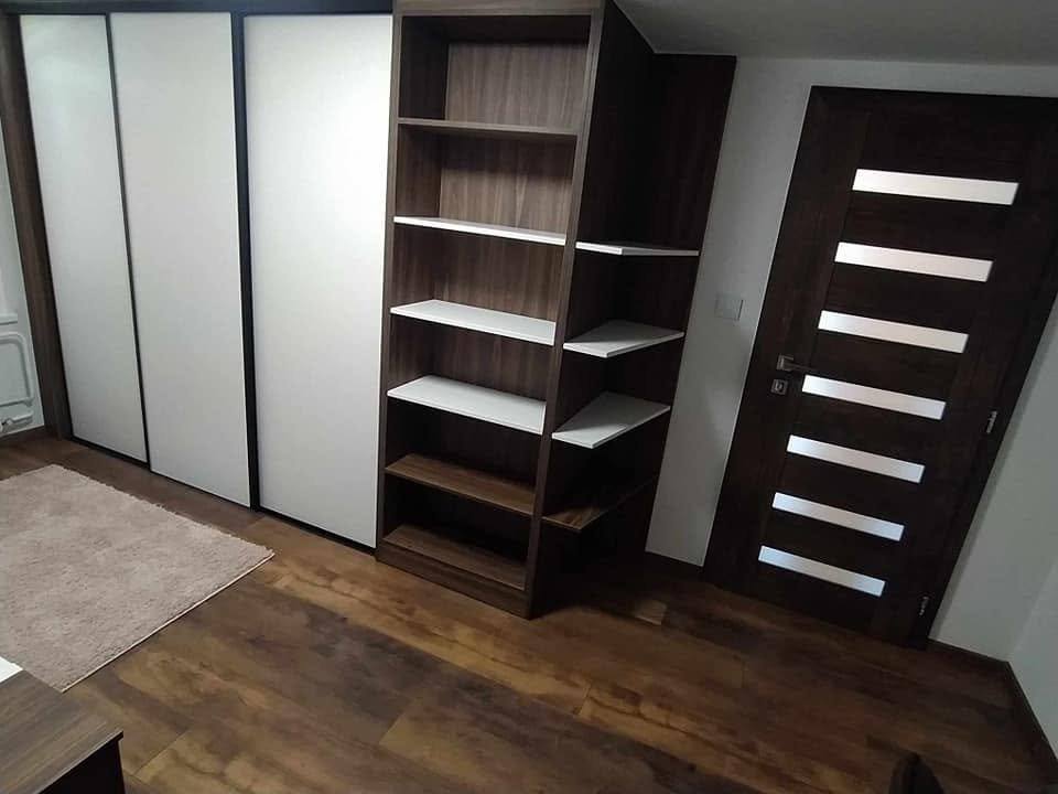 Skriňa s regálom v spálni pri tmavých interiérových dverách