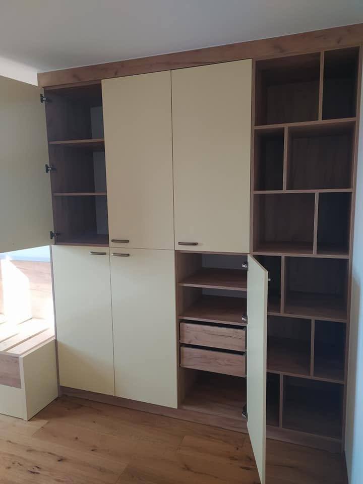 Cremefarbener Kleiderkasten mit offenen Eichenregalen an den Seiten.