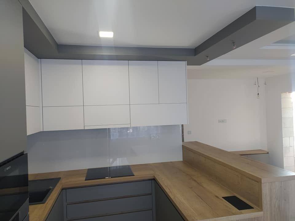 U-Küche mit grauen Laden und Bartheke in Eichendekor