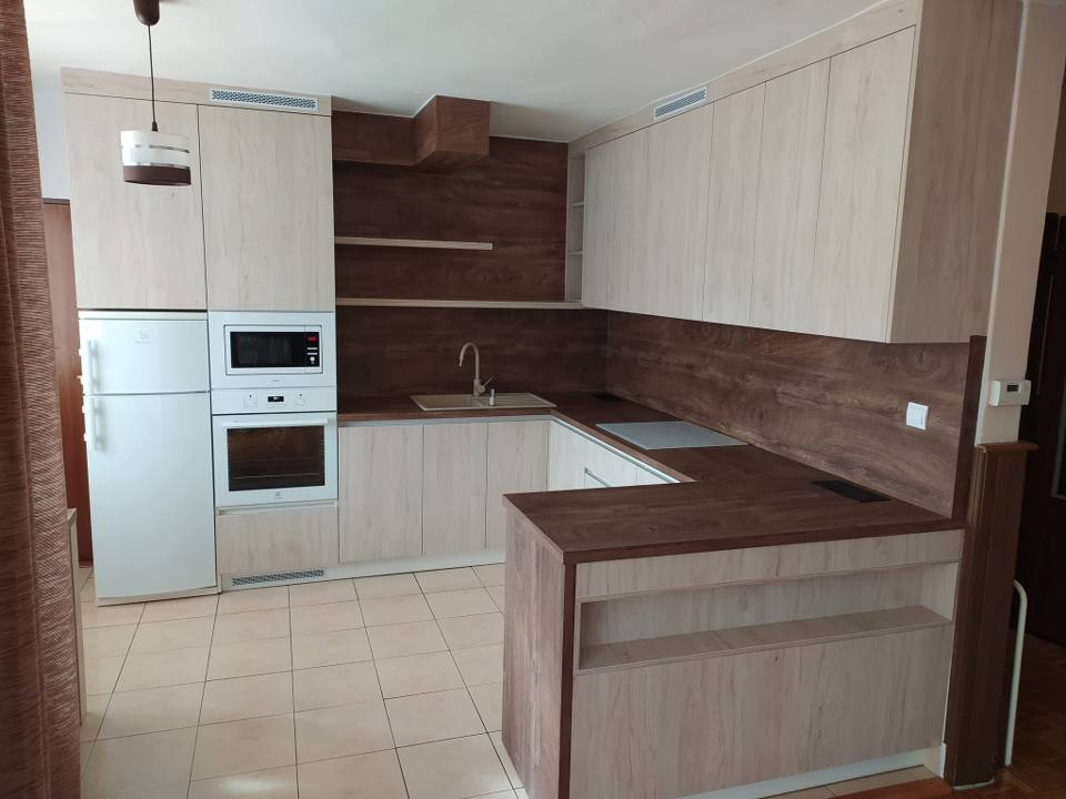 U-Küche mit dunkler Halbinsel und Kühlschrank in der Nische