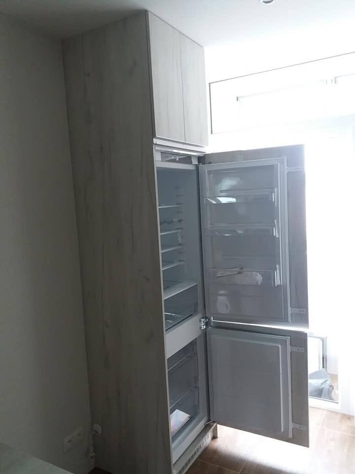 Offener Einbaukühlschrank im hohen Küchenschrank verbaut