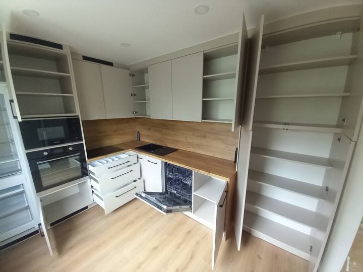 Weiße Küche mit offenen Schränken, Regalen und Laden