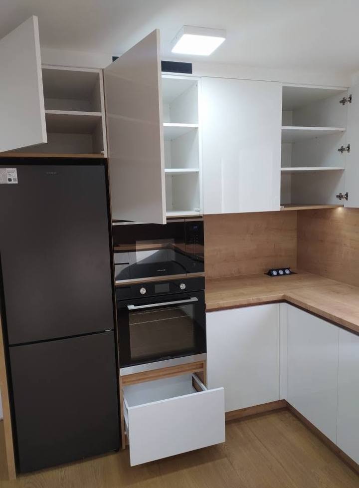 Weiße Küche mit offenen Oberschränken und schwarzem Kühlschrank