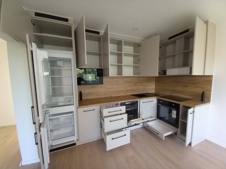 Weiße L-förmige Küche mit offenen Schränken und Kühlschrank