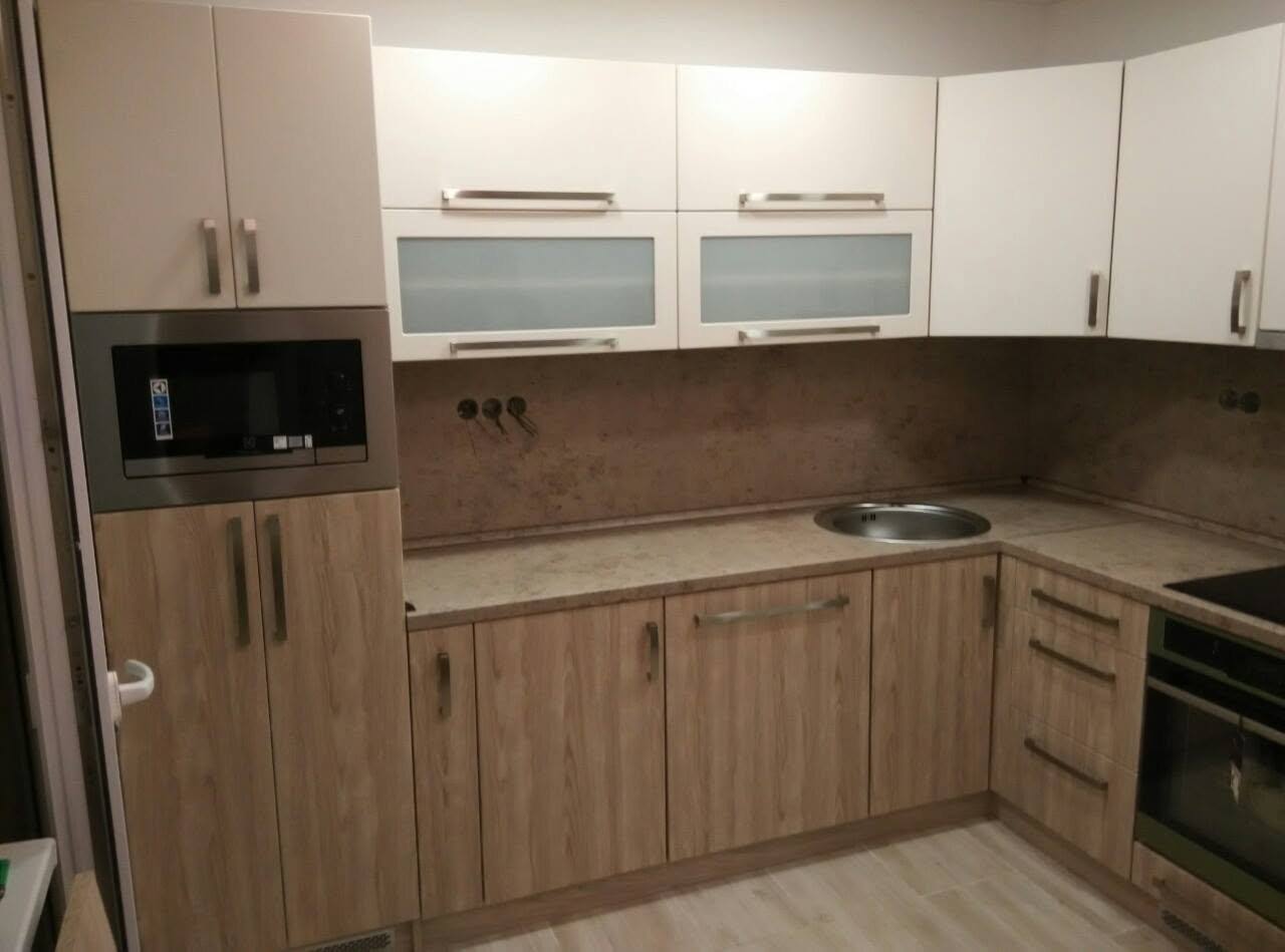 Eichenküche mit weißen Vitrinen und Einbaumikrowelle in der Zeilenmitte.