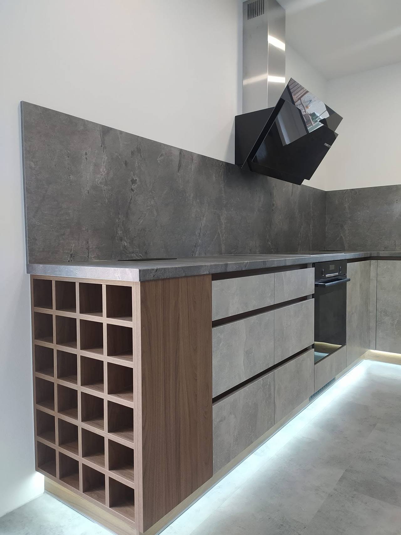 Zeile in Betonoptik mit Weinregal und LED-Sockel