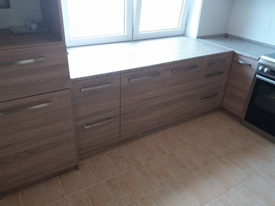 Unterkästen in braunem Holzdekor mit heller Platte unter dem Fenster
