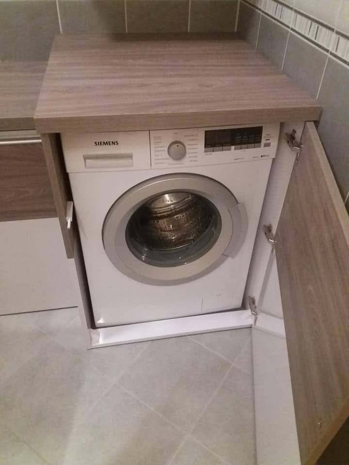 Waschmaschine eingebaut im Badezimmerschrank mit Platte im Holzdekor