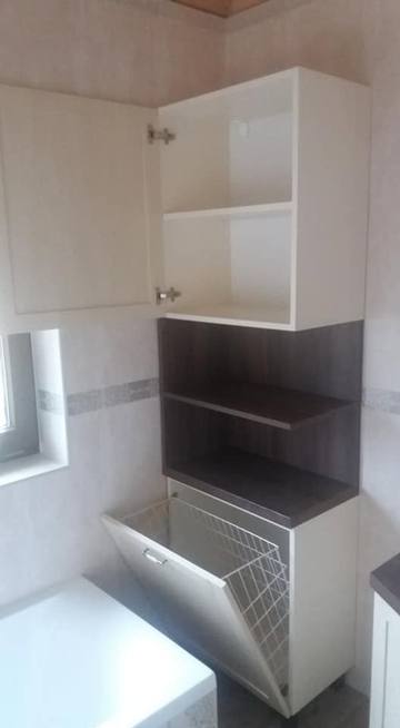 Hoher Badezimmerschrank mit offenen Regalen und Klappkorb