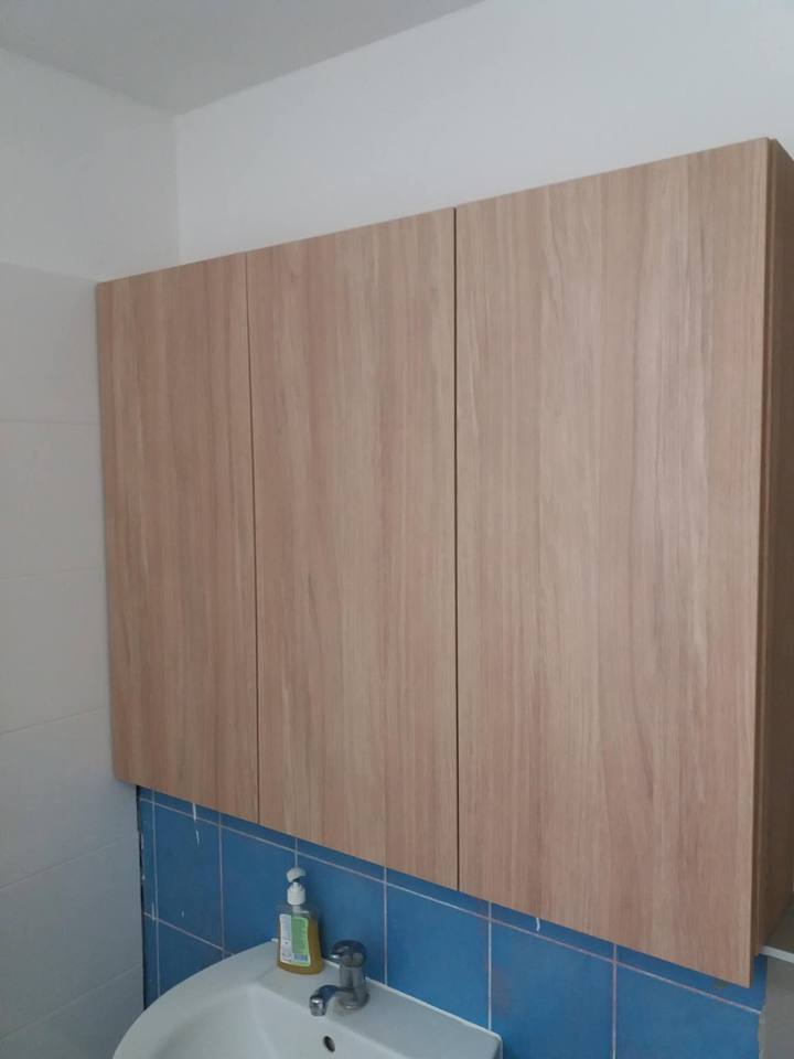 Hängender Eichenschrank über dem Waschbecken mit blauer Verkleidung
