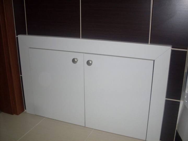 Weißer Einbauschrank im verkleideten Bad mit dunkler Verkleidung