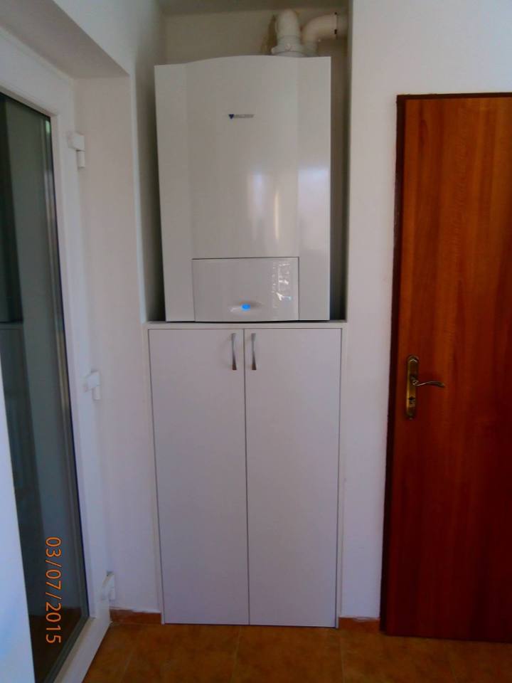 Weißer Hochschrank unter der Gastherme neben der Tür
