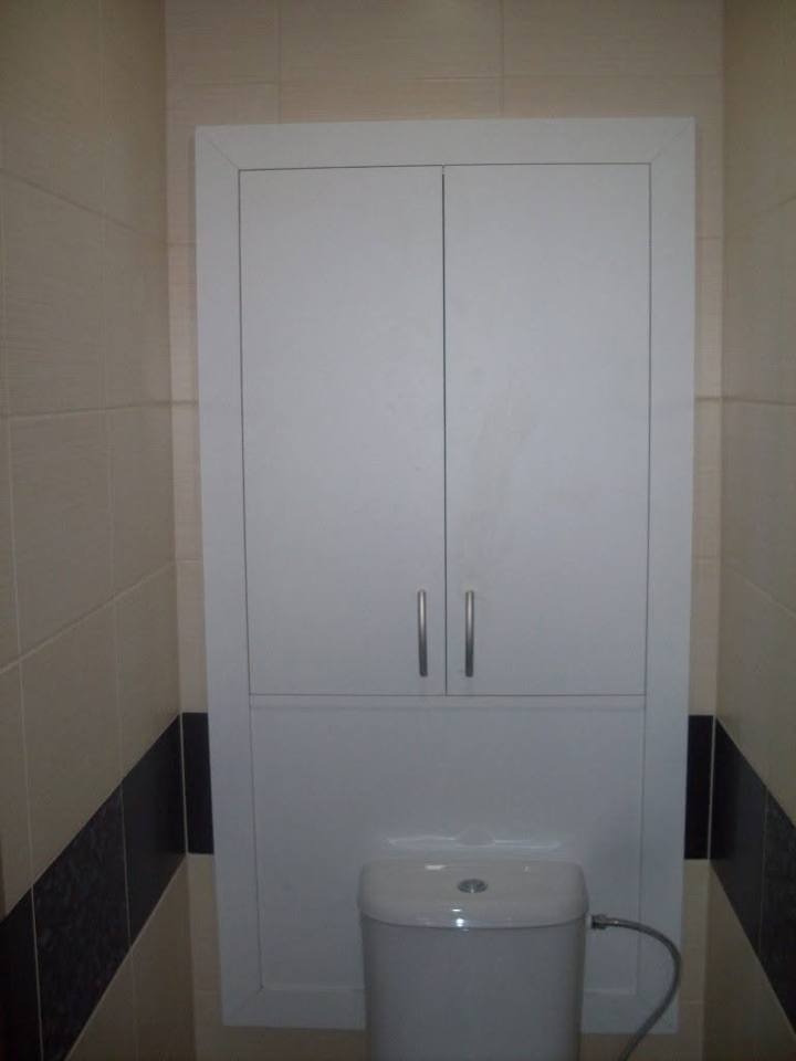 Weißer zweitüriger Schrank über dem WC im Bad