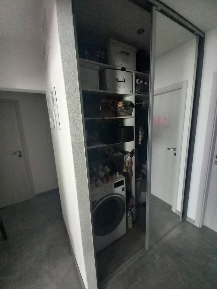 Einbaukasten mit Waschmaschinennische und Regalen hinter Schiebetüren