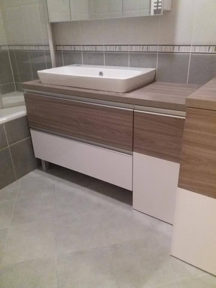 Badschrank mit weißen und holzdekorierten Türen und Becken