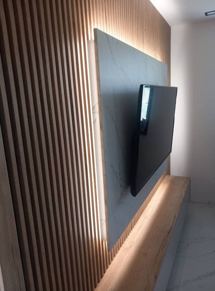 Bočný pohľad na lamely a sivý panel s LED svetlom za televízorom