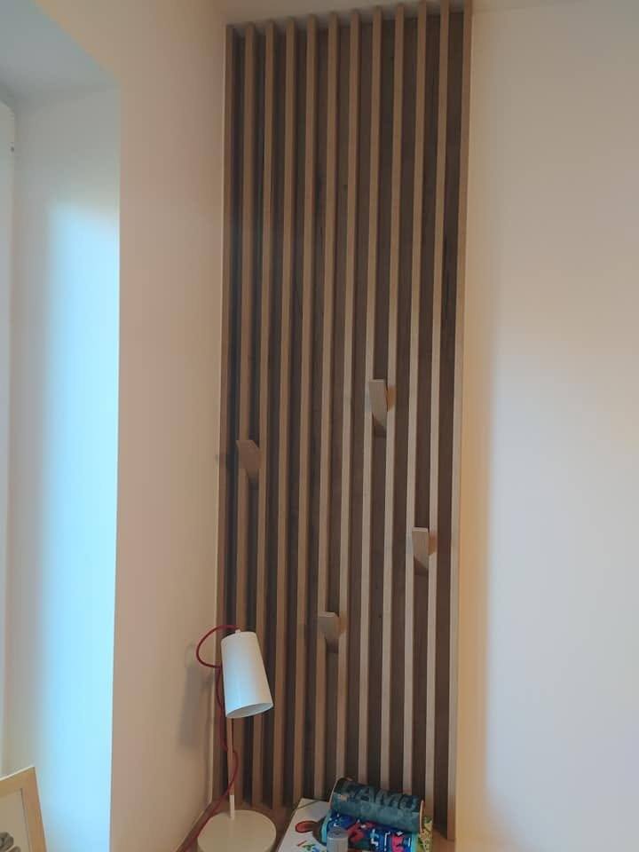 Lamellenwand in Eichendekor vom Boden bis zur Decke beim Fenster