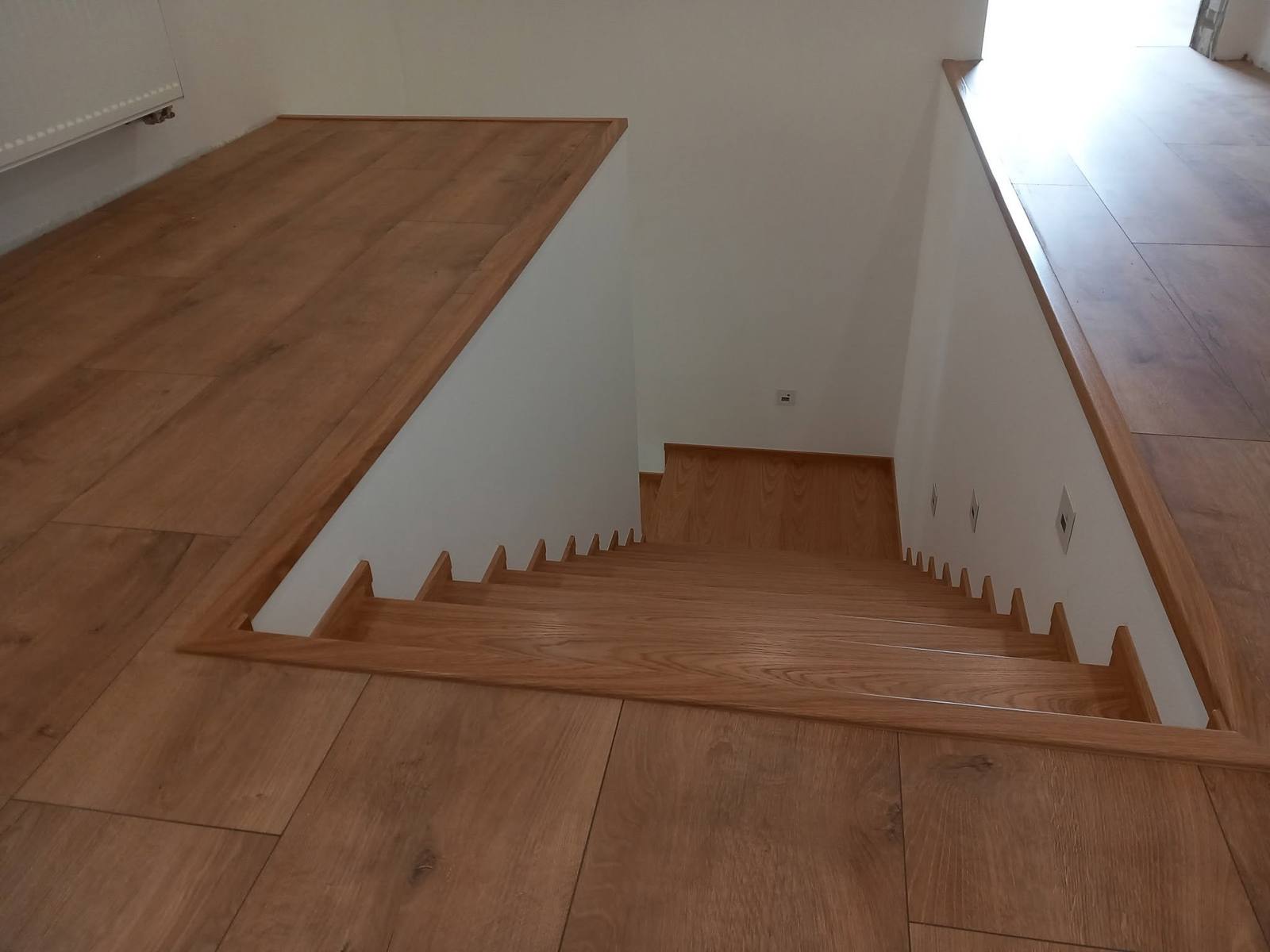 Eichenumrandung der Stiegenöffnung im Anschluss an den Boden