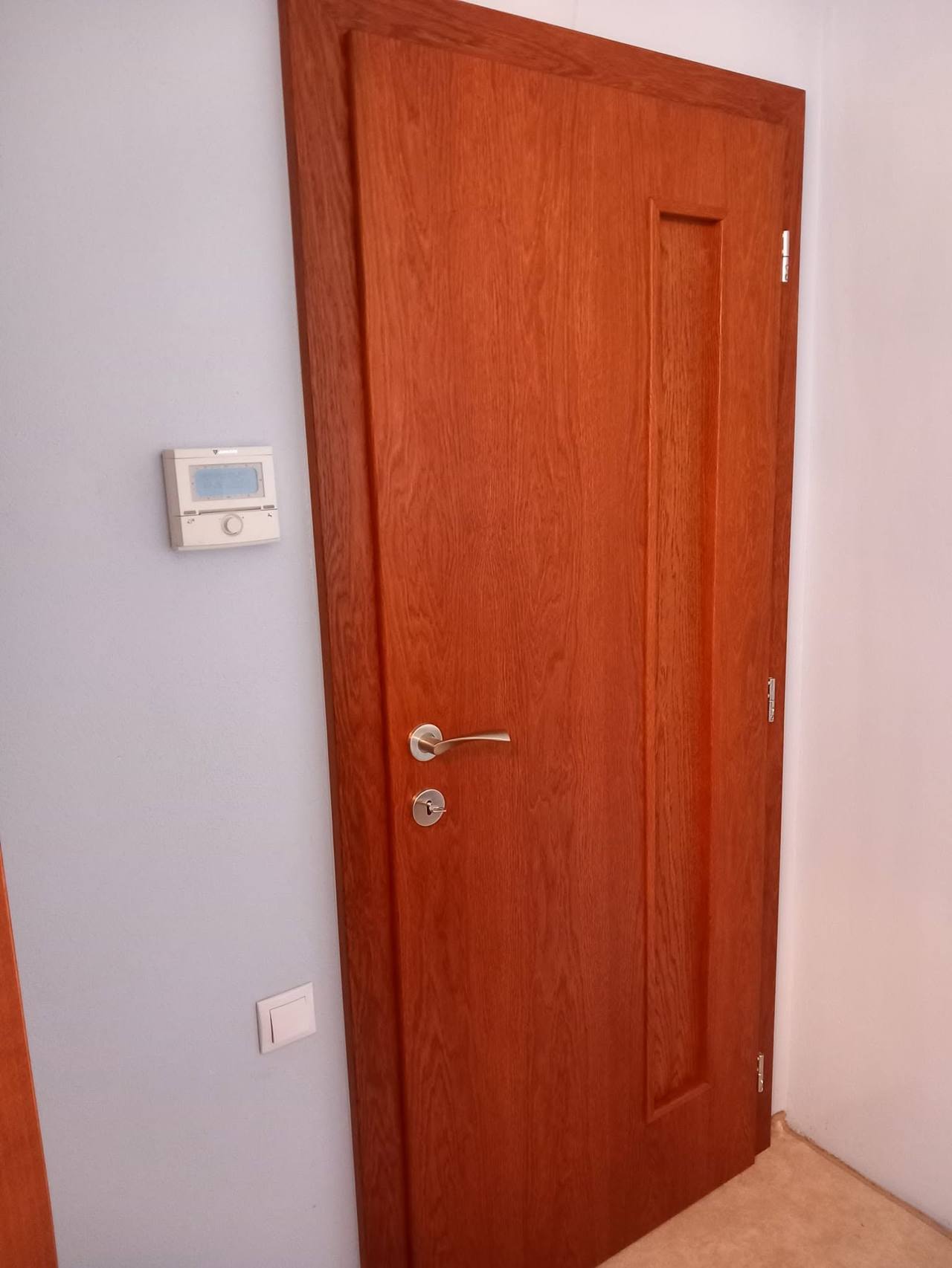 Zatvorené mahagónové dvere vedľa panelu domáceho systému