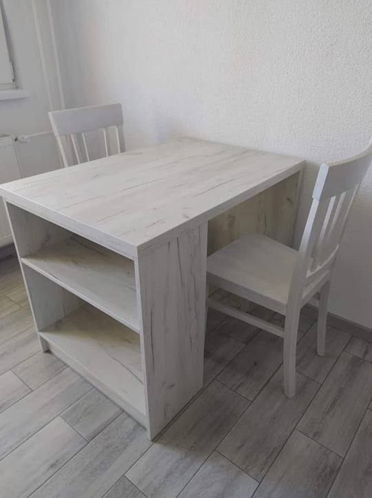 Kleiner Esstisch mit Bord und weißen Stühlen