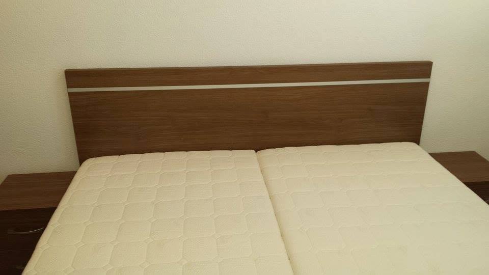 Doppelbett mit dunklem Kopfteil und Aluminiumleiste