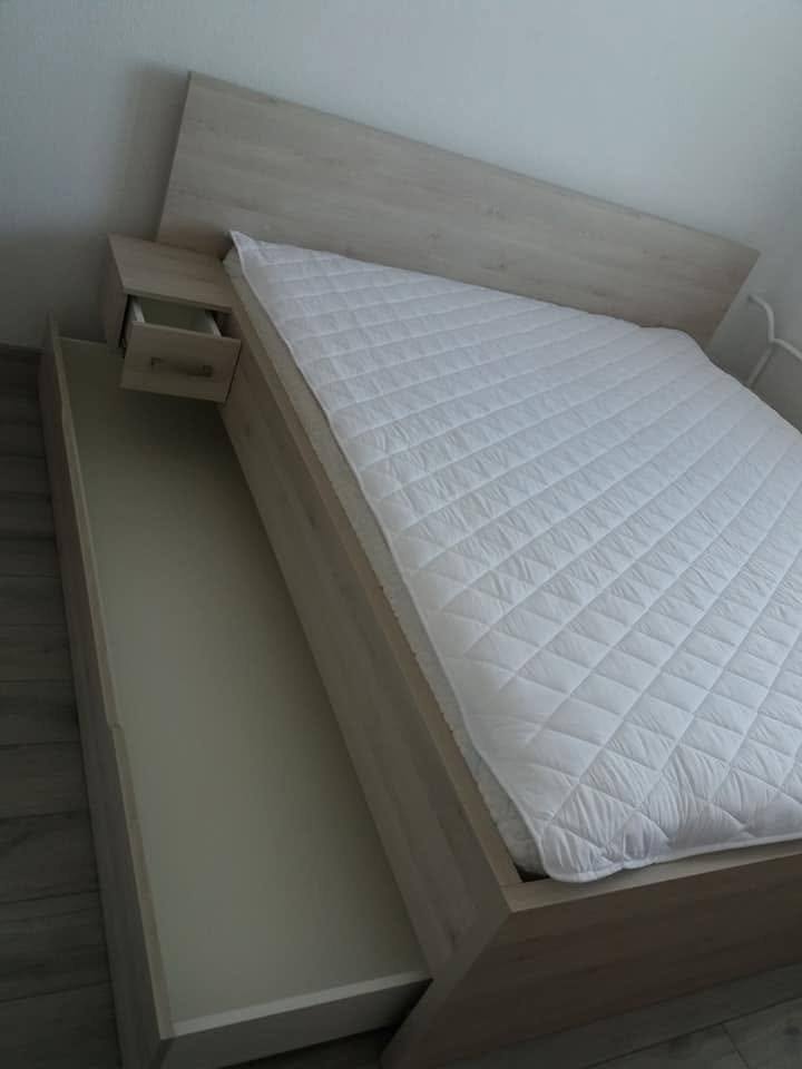 Bett in heller Eiche mit herausgezogener langer Stauraumlade