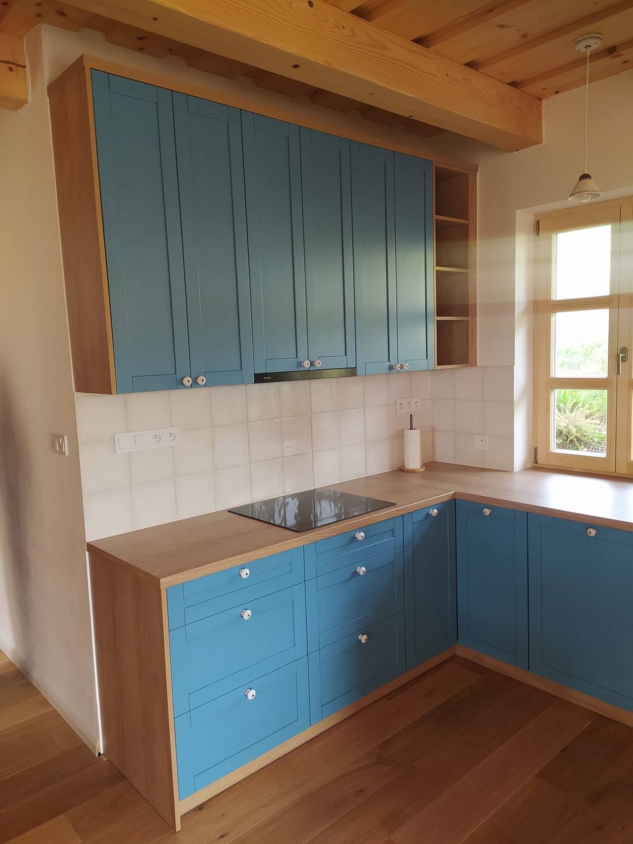 Blaue Hängekästen bis zur Balkendecke über dem Kochfeld