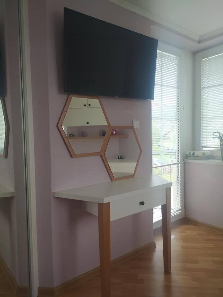 Sechseckiges schwebendes Nachtkästchen unter dem Fernseher im Schlafzimmer