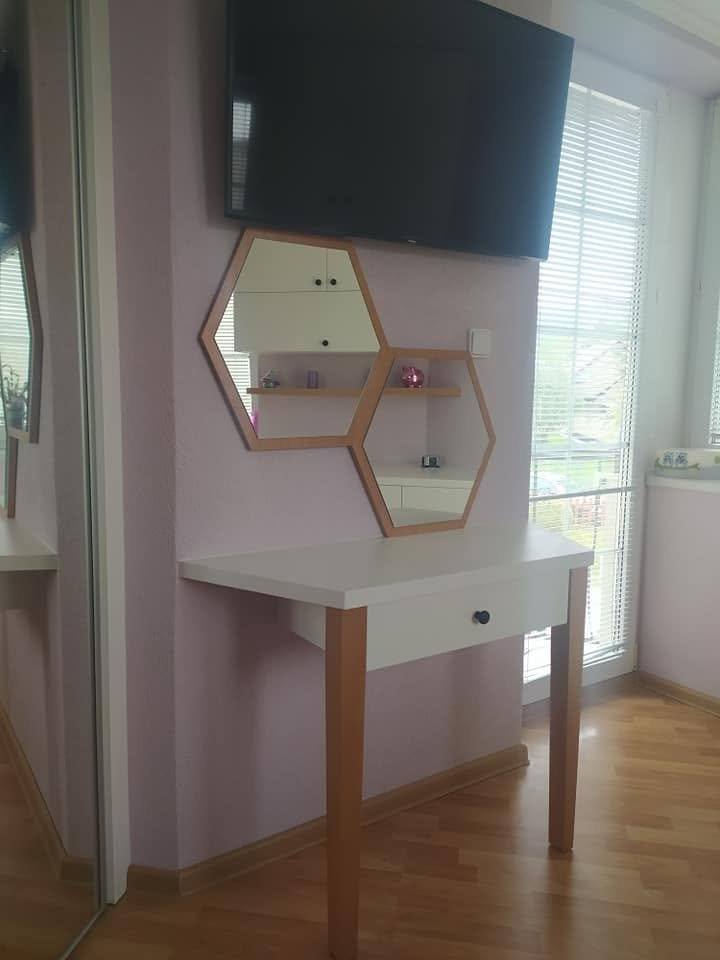 Detail šesťuholníkového nočného stolíka pri fialovej stene