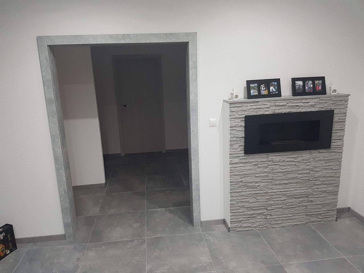 Verkleidete Durchgangsöffnung in Betonoptik neben dem Kamin