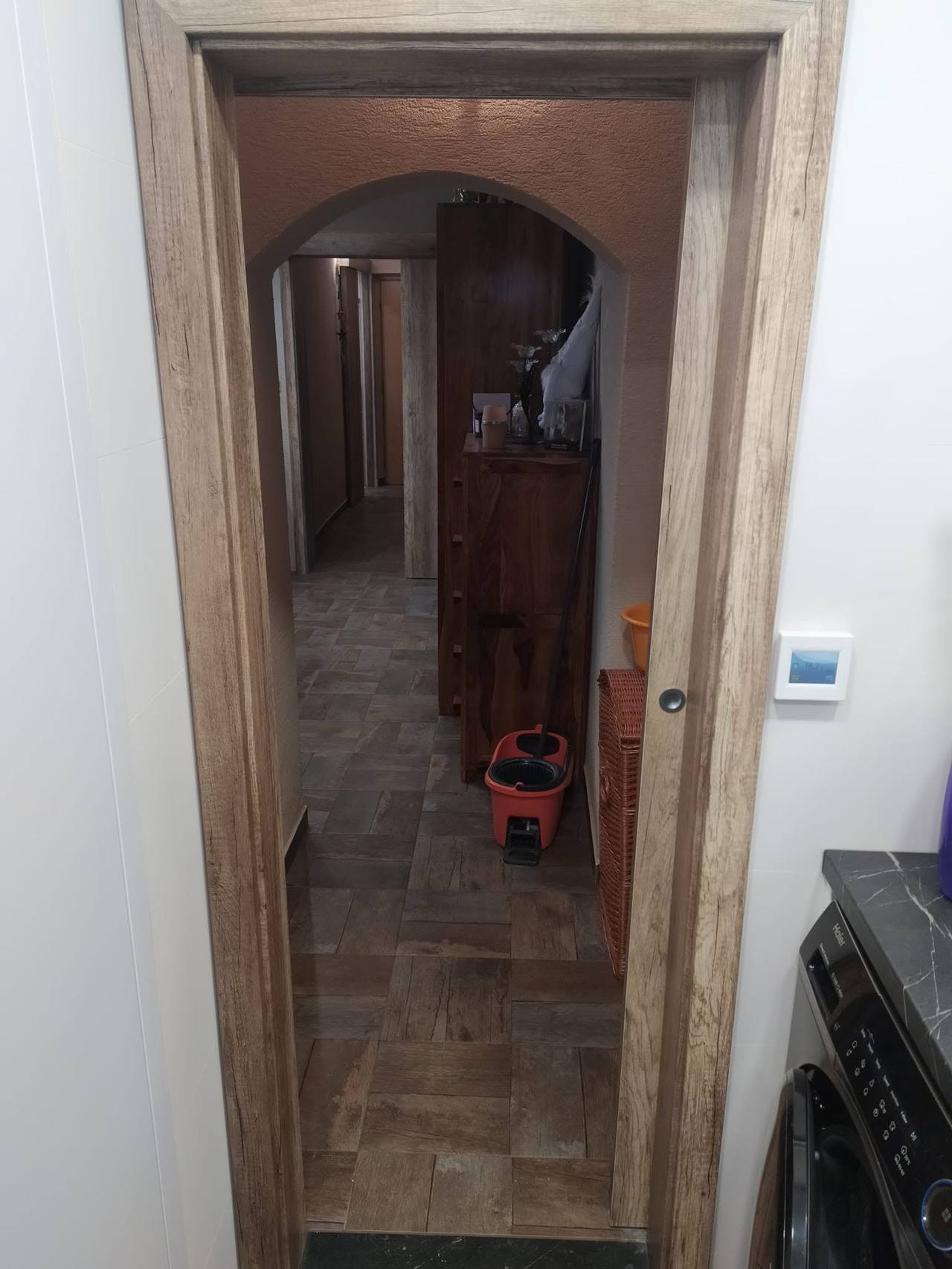Geöffnete angrenzende Tür zum Flur mit dunklem Holzboden