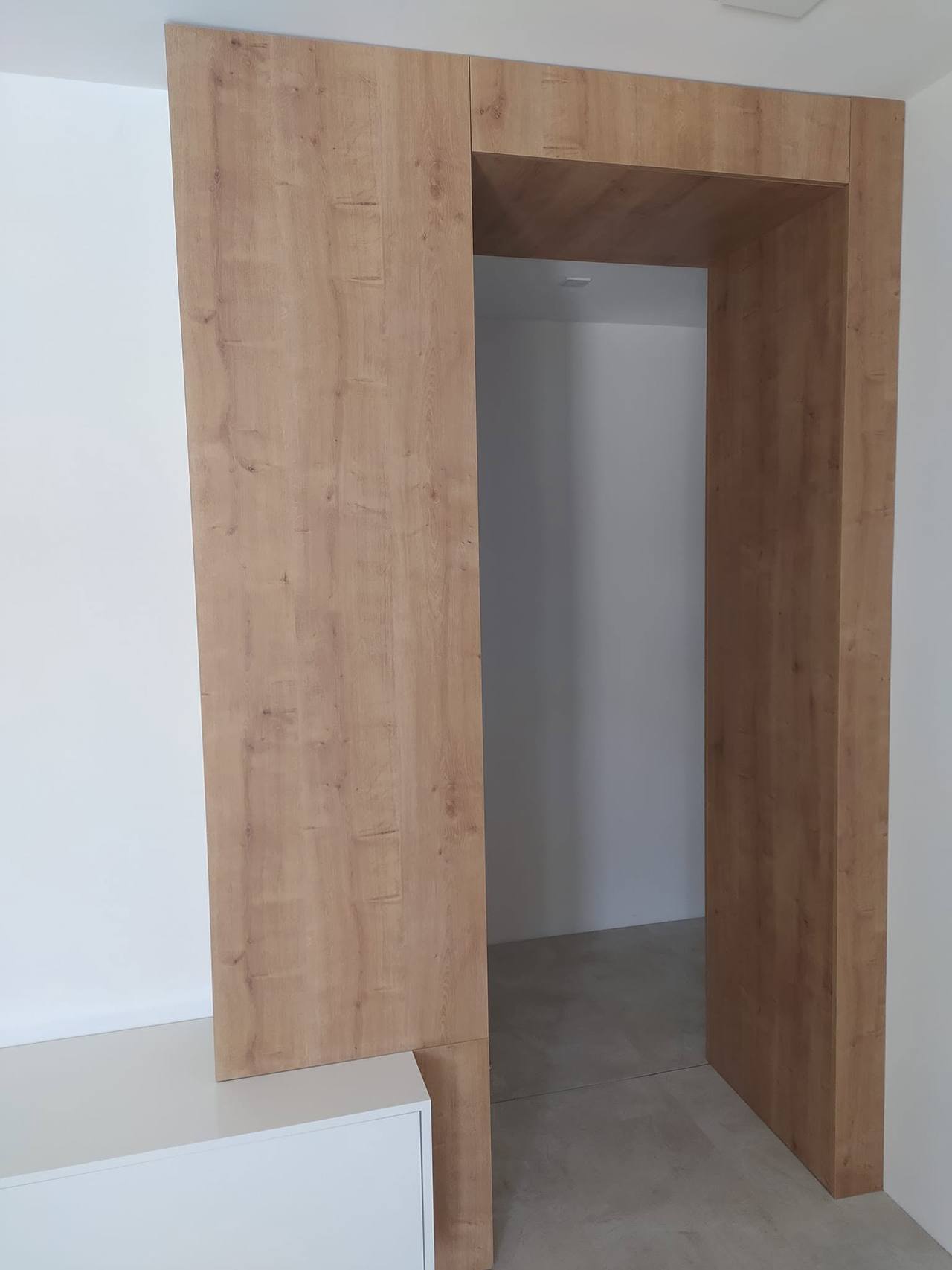 Detail hrúbky orechovej zárubne oproti bielej stene