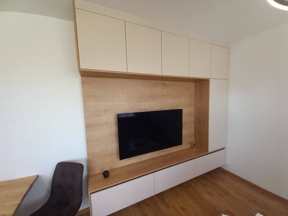Cremefarbene Fächerwand mit Eichen-TV-Rahmen und Arbeitsecke