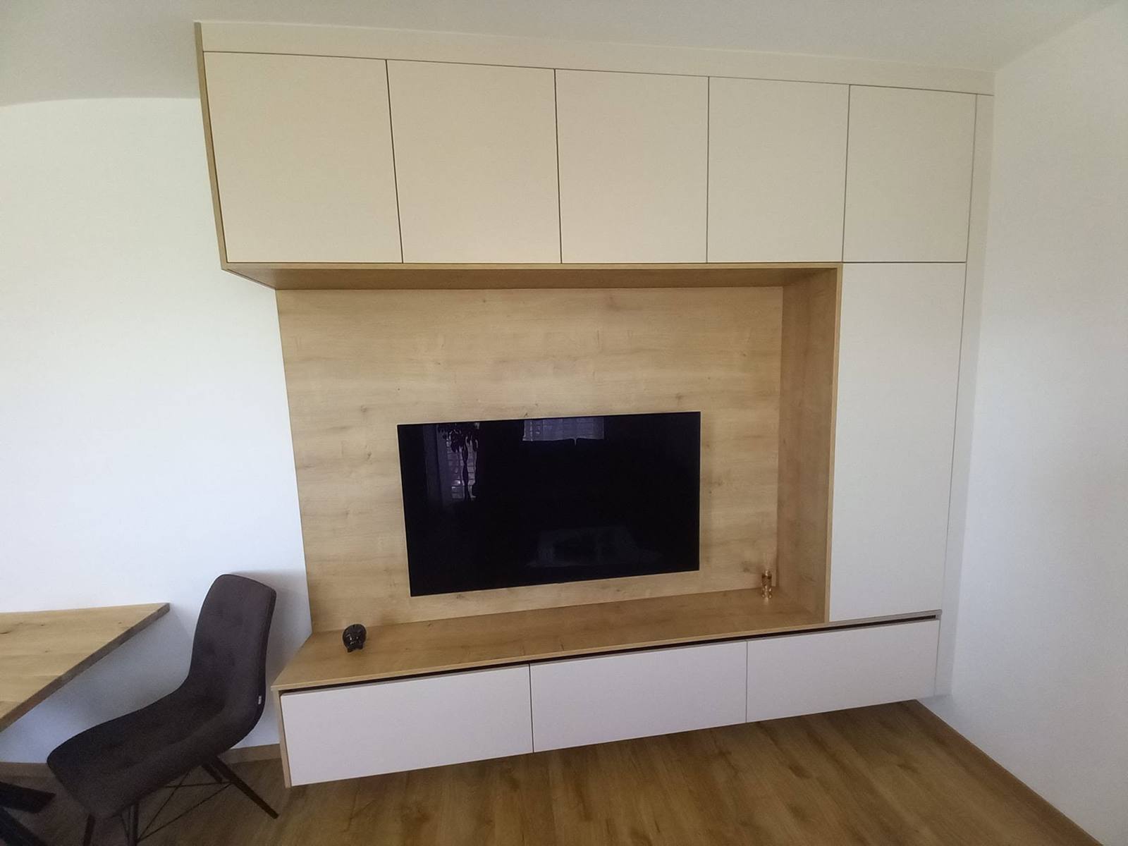 TV-Wand mit cremefarbenen Fächern und Eichenrahmen um den Fernseher