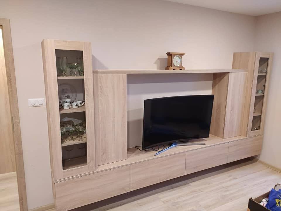 Wohnwand in Eichendekor mit Vitrinen links und rechts vom Fernseher