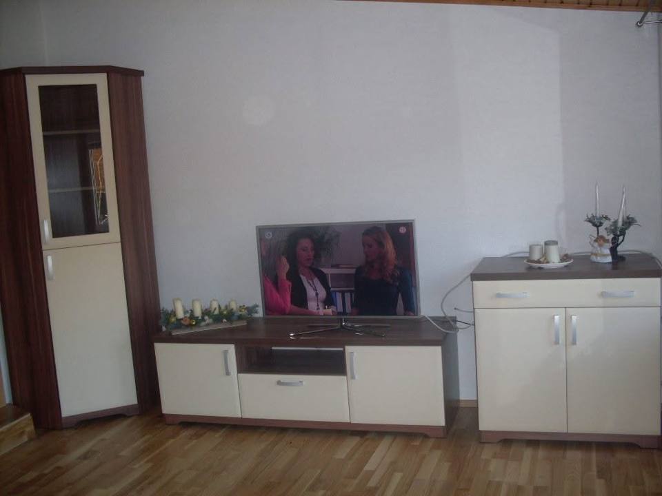 Weißes TV-Lowboard mit Platte in Nussoptik zwischen Vitrine und Kommode