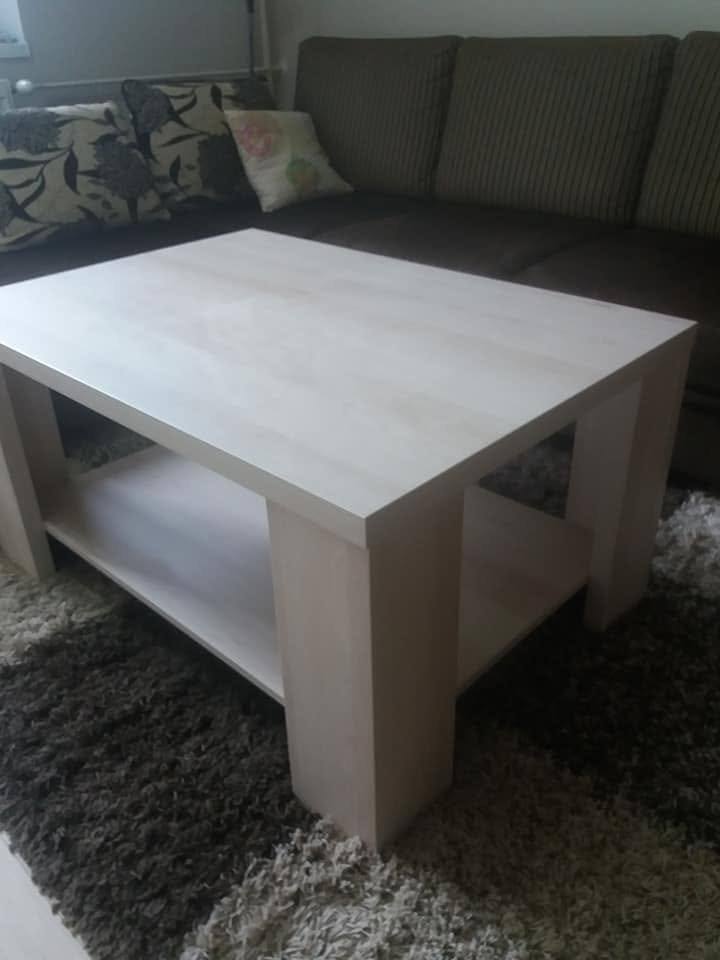 Heller Couchtisch mit Ablage auf grauem Teppich