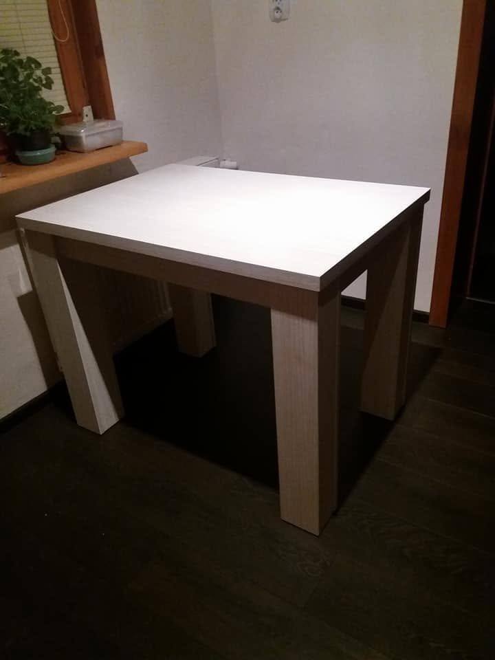 Quadratischer Tisch mit weißer Platte im dunklen Raum