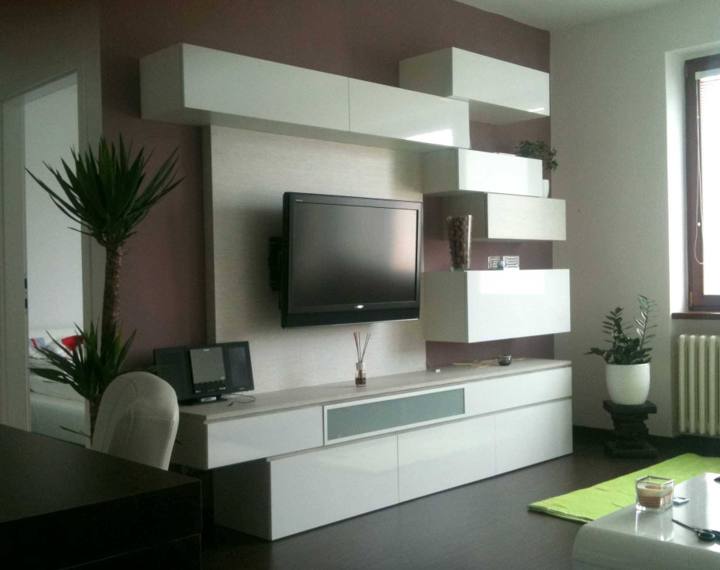 Weiße Wohnwand mit Hängeschränken rund um den Fernseher