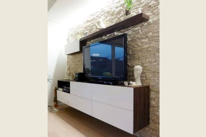 Weißer hängender TV-Schrank mit Nussbaum-Panel bei Steinwand