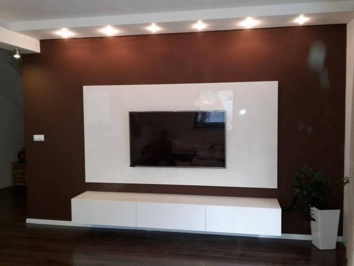 Weiße glänzende TV-Wand vor dunkler Nussbaumwand mit Spots