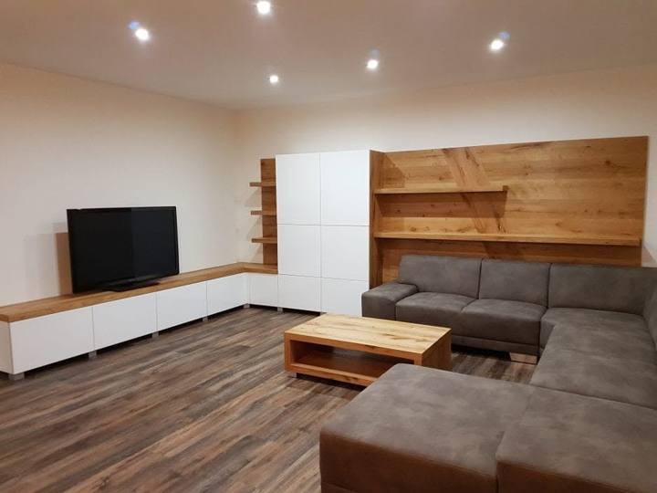 Wohnzimmer mit Eichen-Wandverkleidung und weißen Schränken
