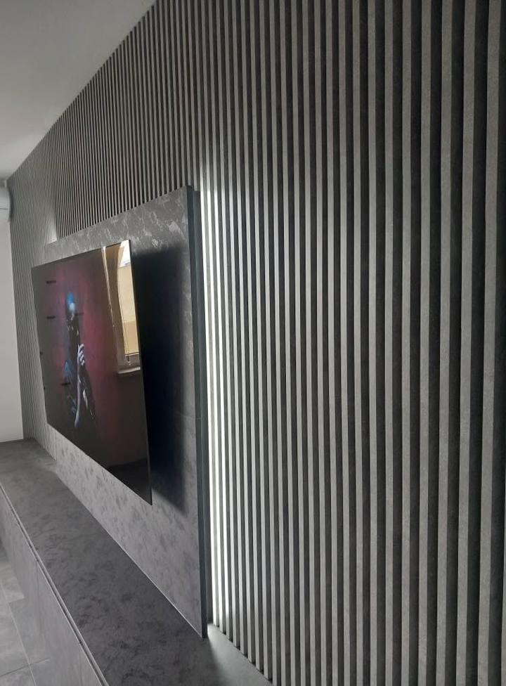 TV-Paneel mit Hinterleuchtung vor grauen Lamellen im Detail
