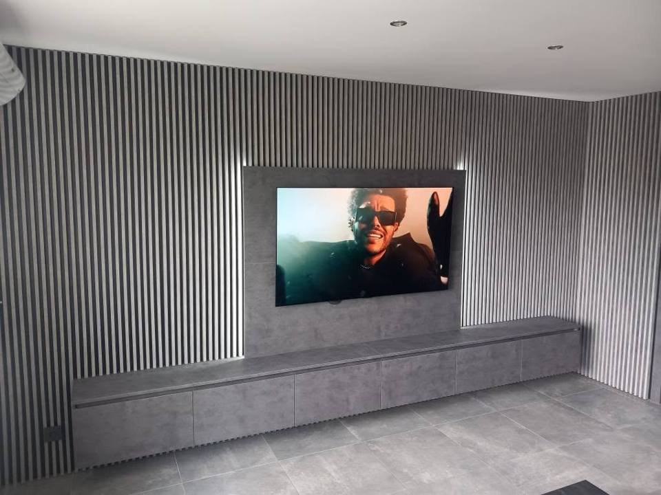 Langes Hängeelement in Betonoptik unter dem beleuchteten Paneel